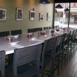 (Gazette Photo by David Taber) The new communal table and art gallery at JP Seafood Café.