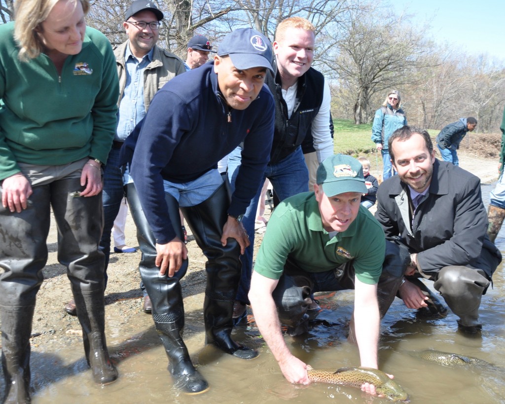 (Photo by Jon Seamans/Boston Parks Dept.) Rick Sullivan (second from right), the state’s energy and environment secretary, releases one of 1,100 trout into Jamaica Pond during the annual fish stocking April 25. Joining him were (from left) state Fish and Game Commissioner Mary Griffin, state Rep. Jeffrey Sánchez, Gov. Deval Patrick, City Councilor Matt O’Malley and City Environment and Energy chief Brian Swett. Anyone with a valid state fishing license can fish in the pond, which is stocked from state hatcheries several times a year.