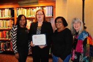 Librarian Jane Bickford (second from left) of Hyde Square’s Connolly Branch Library is honored for 25 years of service by fellow staffers (from left) Fatima Rosario, Nereida Villanueva and Laura Foner at a Nov. 22 Boston Public Library event in the Back Bay. (Photo by Patrick E. O’Connor)