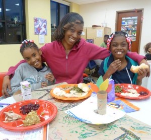 Chemere Jones (center) and her daughters Kahliah Smith, 10 (left), and Khyla Davis, 7 (right), enjoy the Nov. 26 dinner at MSPCC’s JP service center. (Courtesy Photo)