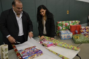 Nick Varano (left), owner of Boston’s Varano Group restaurants, and his daughter Marina wrap gifts for children at the Italian Home for Children in Jamaica Hills on Dec. 19. The Varanos visited with the children and delivered toys from their wish lists. Nick Varano also presented the Home with a donation from Varano Group staff. (Courtesy Photo)