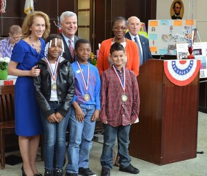 Celebrating the annual “Law Day” event at JP’s West Roxbury District Court house on May 16, where kids learn about the justice system, are (front row, from left) Boston Teachers Union School students and essay-writing award-winners Masiai Deloney, Youri Cius and Cyrus Garcia; and (back row, from left) First Justice Kathleen Coffey, Suffolk County District Attorney Daniel Conley and Dr. Myechia Minter-Jordan, president and CEO of the Dimock Community Health Center. (Courtesy Photo)